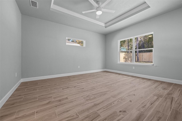 unfurnished room featuring ceiling fan, light hardwood / wood-style flooring, and a raised ceiling