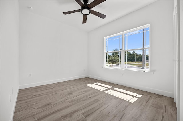 empty room with ceiling fan and light hardwood / wood-style flooring