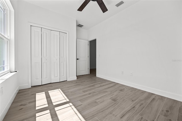 unfurnished bedroom with ceiling fan, a closet, and light hardwood / wood-style floors