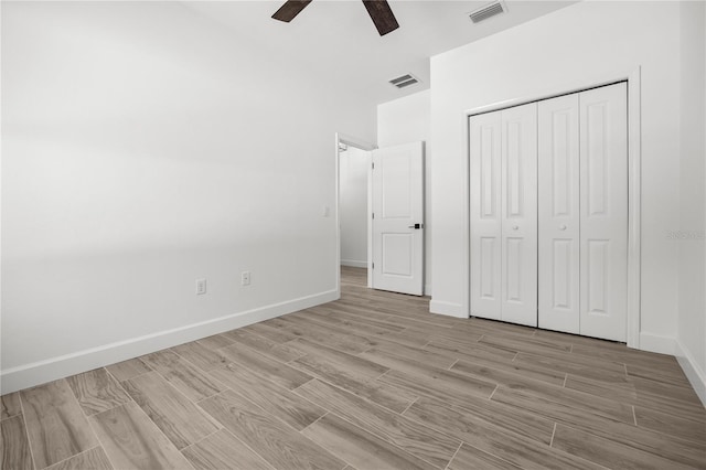 unfurnished bedroom with a closet, light hardwood / wood-style floors, and ceiling fan