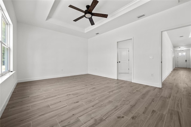 unfurnished room with ceiling fan, light hardwood / wood-style flooring, crown molding, and a healthy amount of sunlight