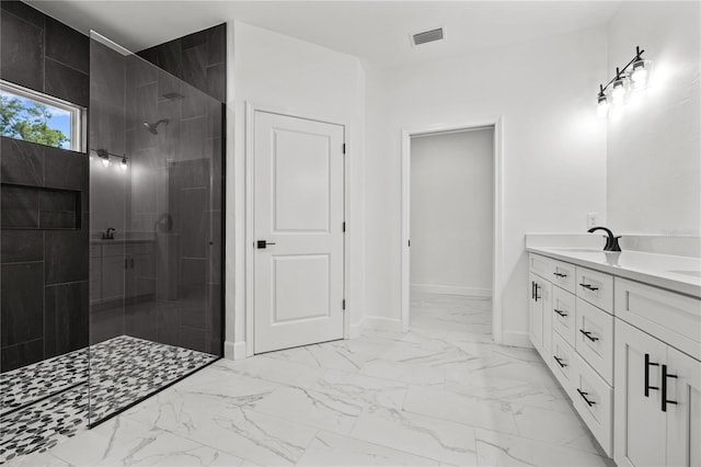 bathroom with vanity and tiled shower