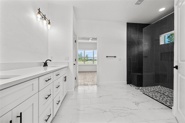 bathroom with plenty of natural light, vanity, and tiled shower