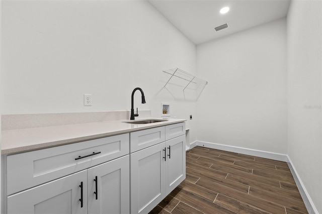 clothes washing area featuring hookup for a washing machine, hookup for an electric dryer, cabinets, dark hardwood / wood-style floors, and sink