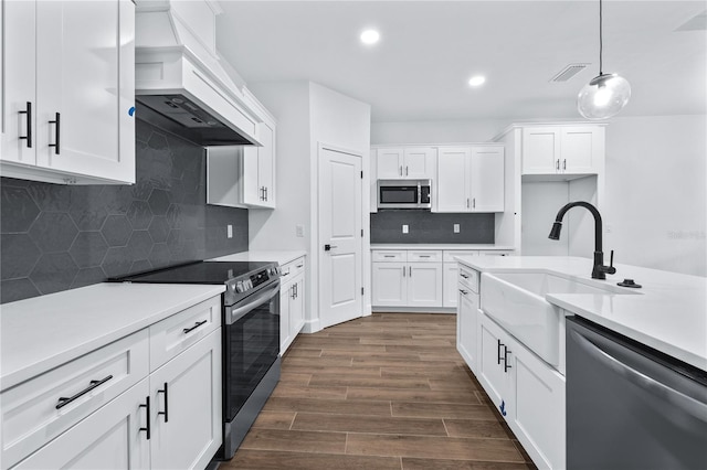 kitchen with dark hardwood / wood-style flooring, custom exhaust hood, stainless steel appliances, and white cabinets