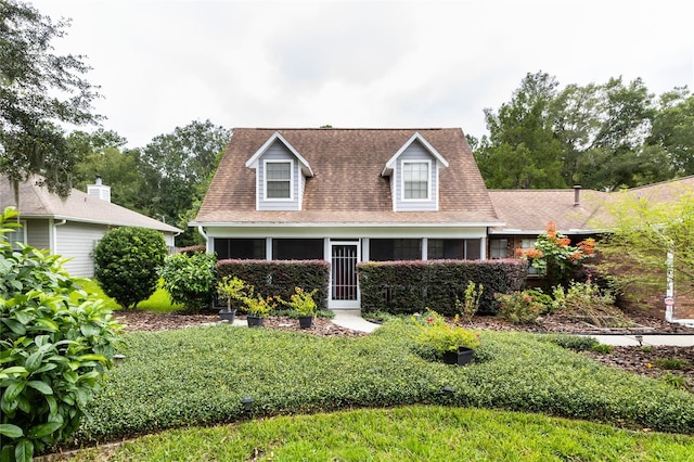 cape cod house featuring a front yard