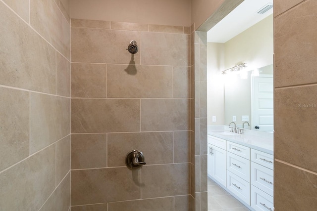 bathroom featuring tile patterned floors, vanity, and tiled shower