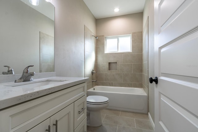 full bathroom with tile patterned flooring, vanity, tiled shower / bath combo, and toilet