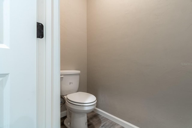 bathroom featuring hardwood / wood-style flooring and toilet