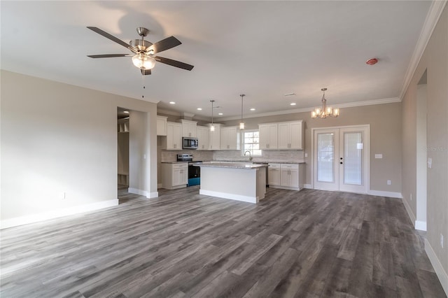 kitchen with stainless steel appliances, white cabinets, hardwood / wood-style floors, a kitchen island, and hanging light fixtures