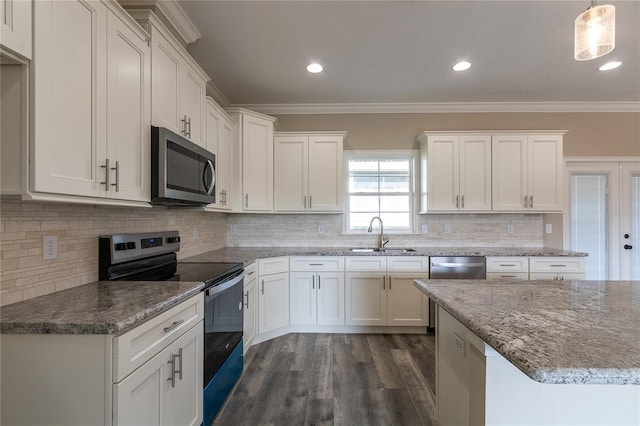 kitchen with appliances with stainless steel finishes, decorative light fixtures, white cabinetry, and sink