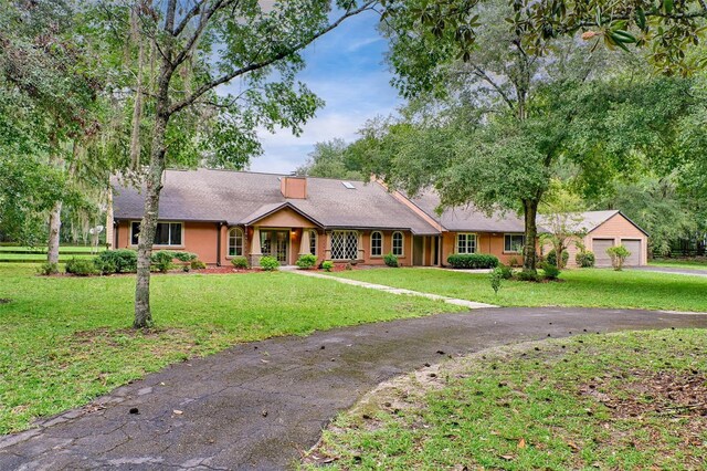 ranch-style house with a garage and a front lawn