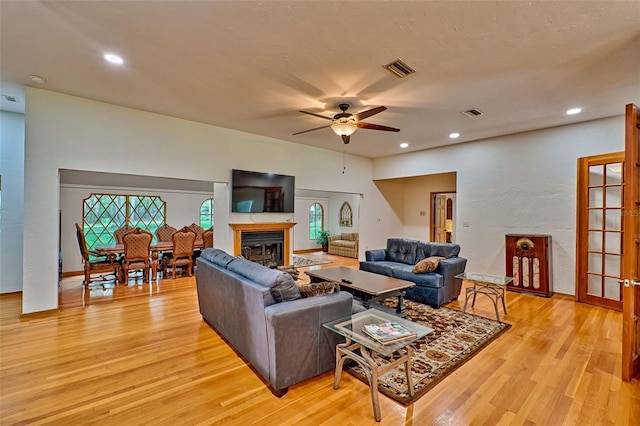 living room featuring light hardwood / wood-style flooring and ceiling fan