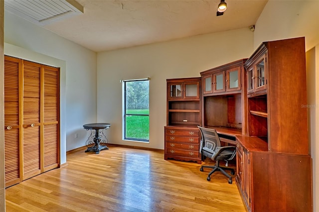 home office with light hardwood / wood-style flooring and lofted ceiling