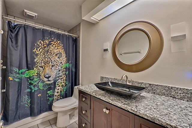 bathroom with vanity, toilet, and tile patterned floors