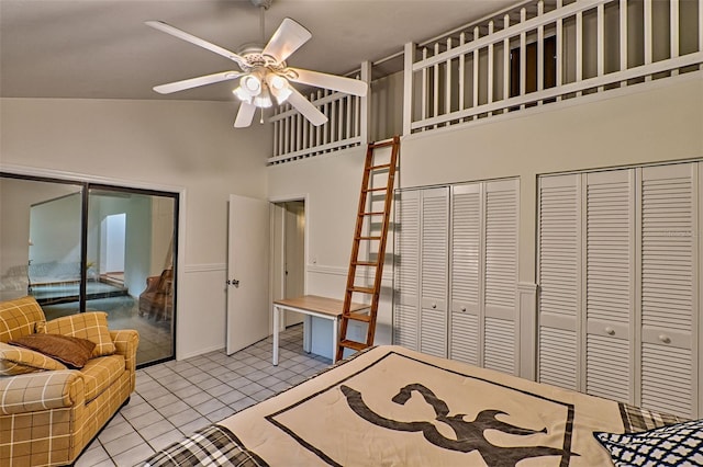 interior space featuring light tile patterned floors, two closets, ceiling fan, and high vaulted ceiling