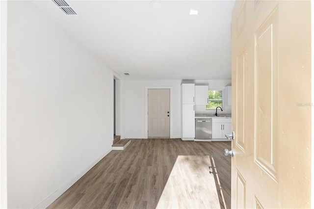 interior space featuring light wood finished floors, baseboards, and visible vents