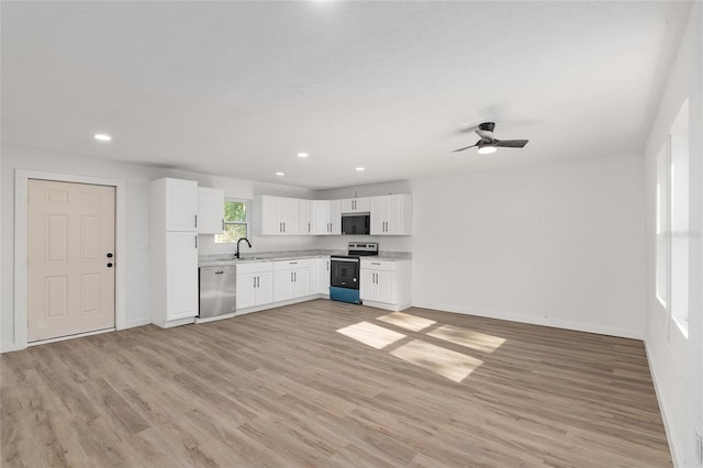 kitchen featuring stainless steel appliances, light wood-type flooring, ceiling fan, white cabinets, and sink