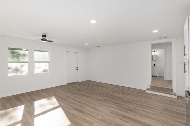 spare room with ceiling fan and light wood-type flooring