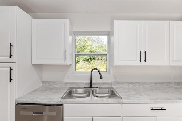 kitchen with sink, stainless steel dishwasher, and white cabinetry