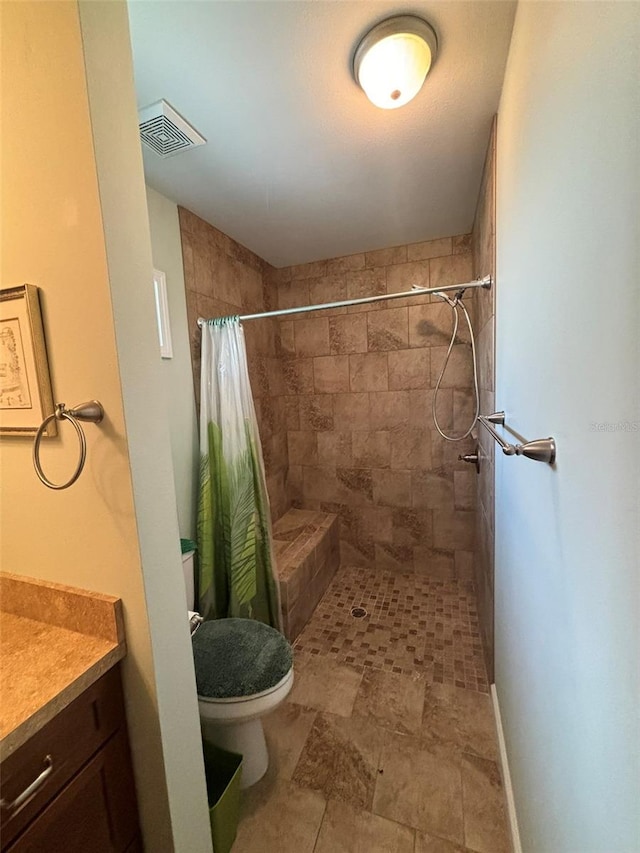 bathroom with walk in shower, vanity, and toilet