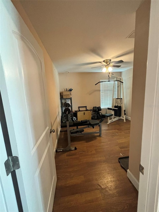 exercise room with dark hardwood / wood-style floors and ceiling fan