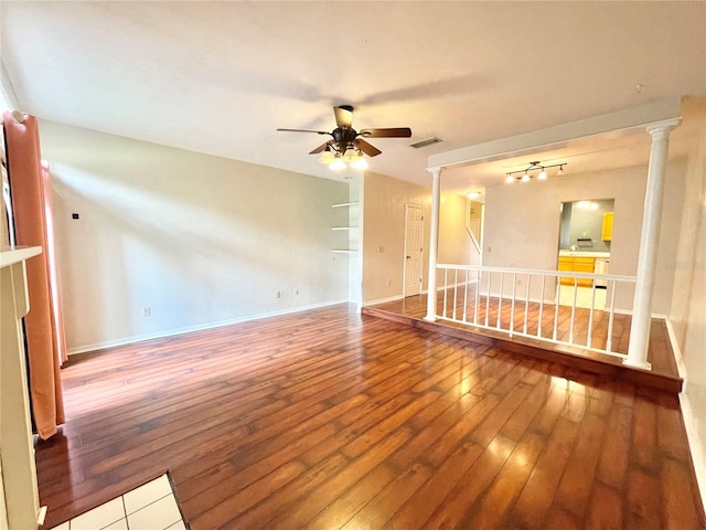 unfurnished room featuring ceiling fan, hardwood / wood-style flooring, and ornate columns