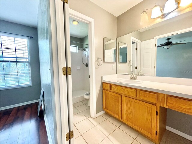 bathroom with vanity, walk in shower, ceiling fan, hardwood / wood-style flooring, and toilet