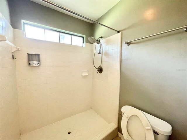 bathroom featuring toilet and tiled shower