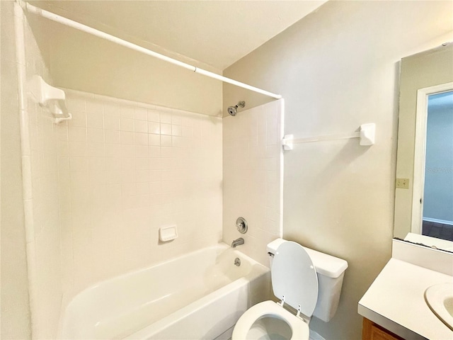 full bathroom with tiled shower / bath, vanity, and toilet