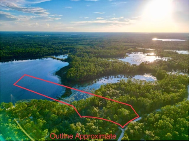 aerial view at dusk featuring a water view