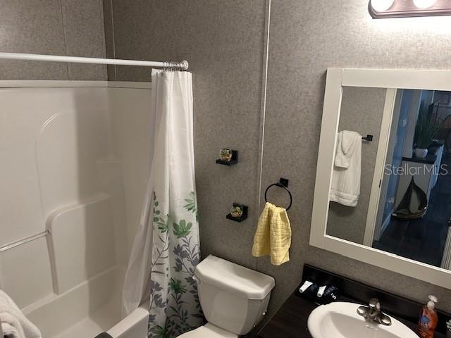 full bathroom with shower / tub combo, sink, and toilet