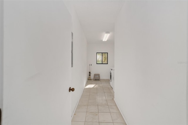 hall with light tile patterned floors and separate washer and dryer