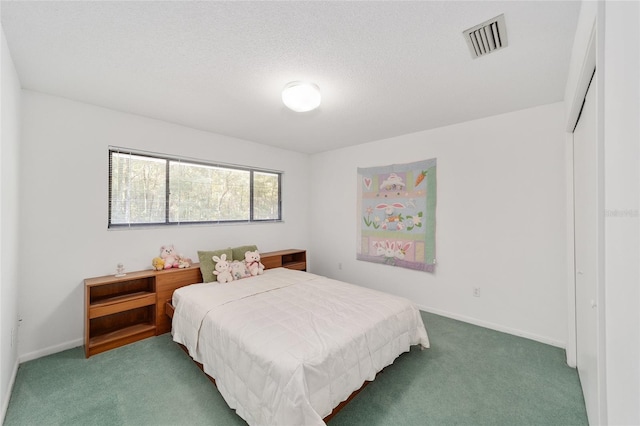 bedroom with a textured ceiling and dark colored carpet