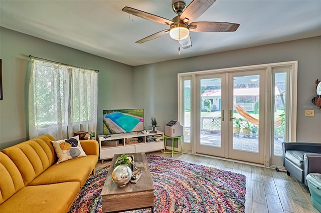 living room with hardwood / wood-style floors, ceiling fan, and french doors