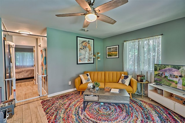 living room featuring ceiling fan and light hardwood / wood-style floors