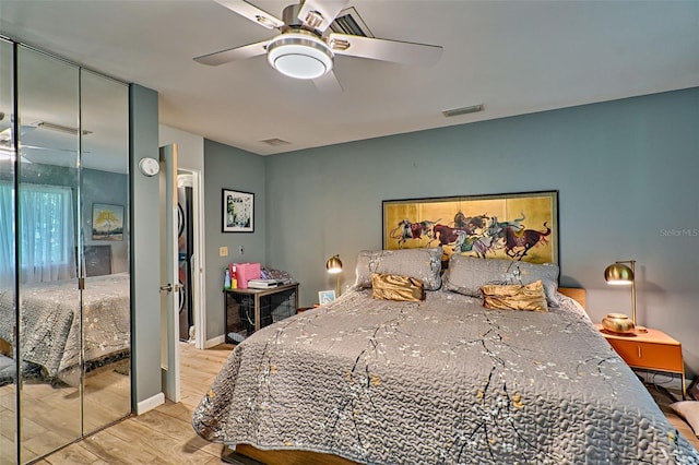 bedroom with light hardwood / wood-style floors, ceiling fan, and a closet