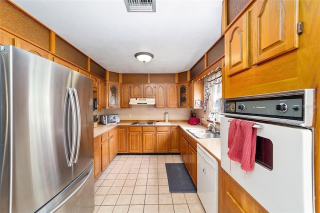 kitchen with white appliances, sink, and light tile patterned floors