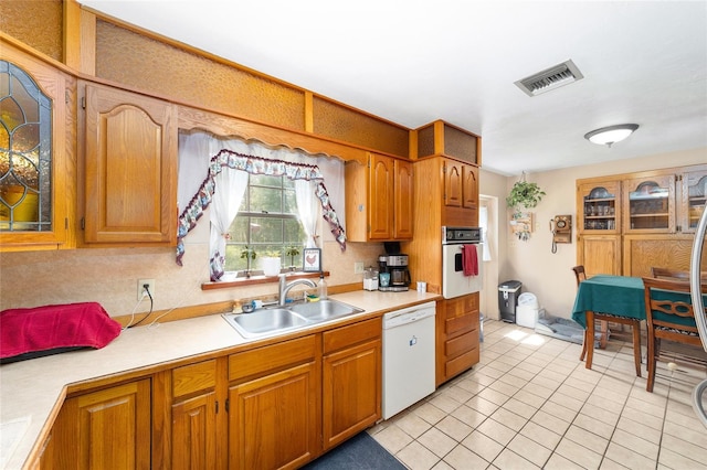 kitchen with white appliances, light tile patterned flooring, and sink