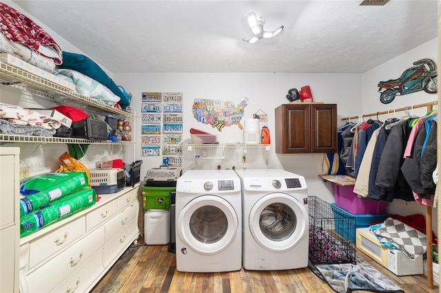 laundry area with cabinets, dark hardwood / wood-style floors, and washer and clothes dryer