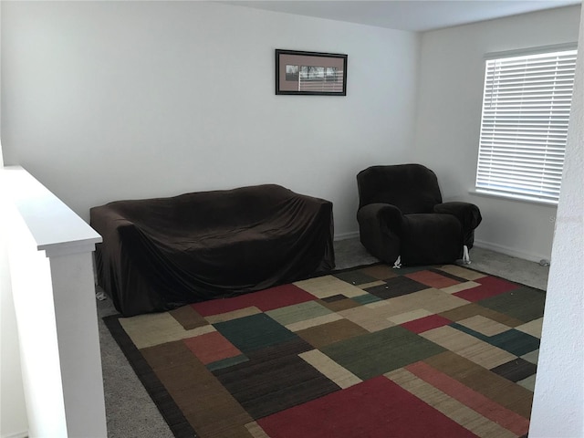 sitting room featuring dark carpet and plenty of natural light