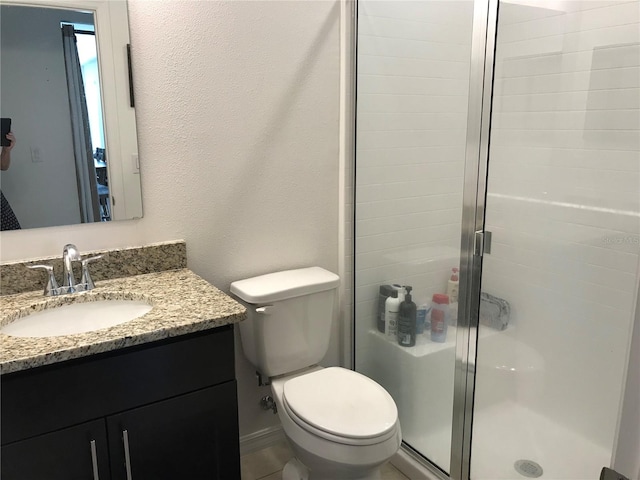 bathroom featuring walk in shower, vanity, and toilet