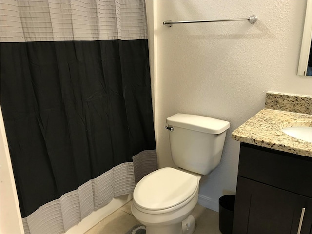 bathroom featuring walk in shower, vanity, tile patterned flooring, and toilet