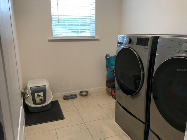 laundry area with light tile patterned flooring and washer and dryer