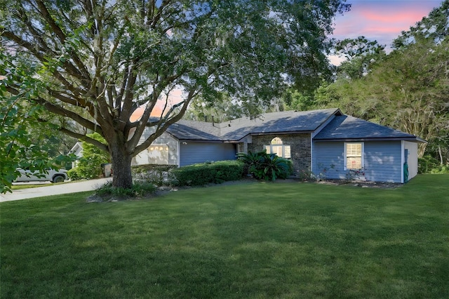 ranch-style home with a lawn