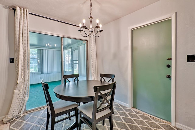 dining space featuring carpet floors and a chandelier