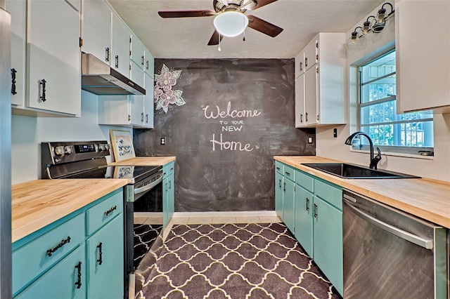 kitchen with white cabinets, butcher block countertops, stainless steel appliances, ceiling fan, and sink