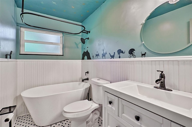 bathroom with tile patterned floors, a washtub, vanity, and toilet