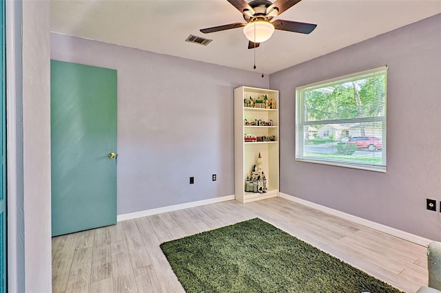 spare room with light wood-type flooring and ceiling fan