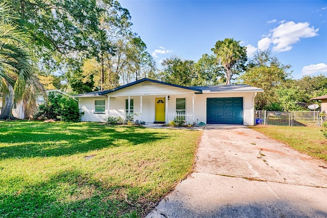 ranch-style home with a garage, a front yard, and covered porch